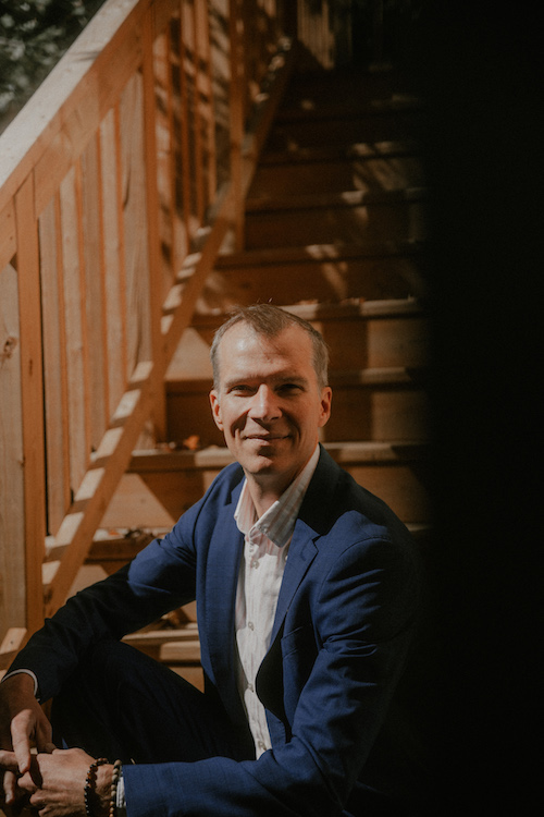 Steven Haase seated on wooden stairs
